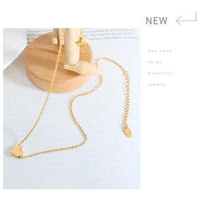 Detailed close-up of a gold heart pendant necklace with adjustable chain and lobster clasp