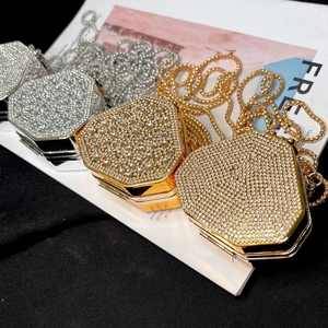 Close-up of sparkling rhinestone-encrusted hexagonal evening clutch bags with gold chains
