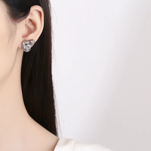 Exquisite silver butterfly stud earrings with realistic textures worn by model