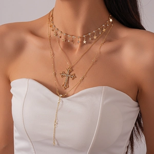 Detail of layered gold necklaces with sparkling rhinestone cross and star pendants