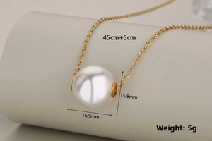 Detail view of large white pearl pendant on gold chain with dimensions 16x17mm