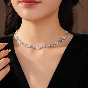 Detail of silver geometric link necklace with clear cubic zirconia on a model neck