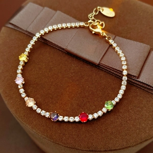 Detailed close-up of multi-color zircon tennis bracelet on a brown velvet jewelry box