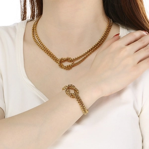 Two-layer gold pearl knot jewelry set in stainless steel worn by a fashion model
