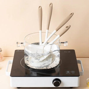 Dual-color silicone kitchen utensil set with spatulas and spoons in a boiling pot