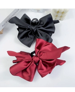 Detail of large satin bow hair clips in black and wine red with premium silk texture