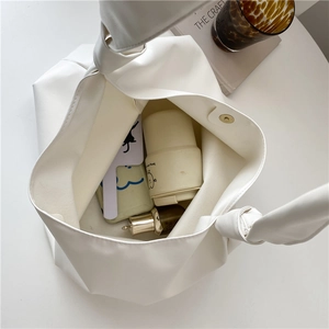 Minimalist white leather tote bag with knot shoulder strap showing large capacity interior