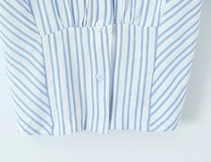 Close-up of blue and white striped seersucker fabric with white button details