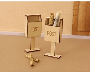 Macro shot of miniature wooden post boxes and tiny rolled newspapers for dollhouse scenes