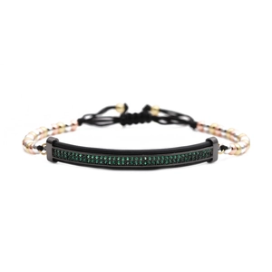 Détail du bracelet tressé ajustable avec pierres vertes et perles métalliques tricolores