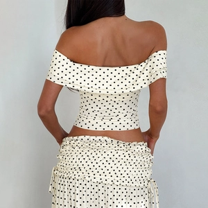 Detail showing elastic smocked waist and side tie on polka dot tiered maxi skirt