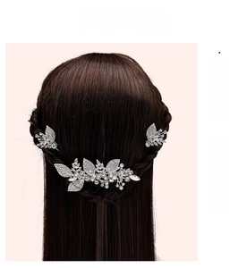 Macro detail of bridal silver rhinestone hair comb set on deep brown braided hair