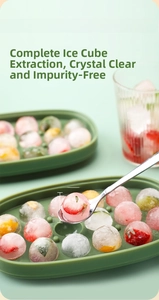 Macro shot of 2.5cm round ice spheres with fruit slices made in a green silicone mold