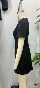 Détail latéral d'une robe noire à manches courtes avec fronces aux épaules et coupe ajustée