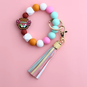 Macro shot of colorful silicone beads keychain with floral charm and leather tassel