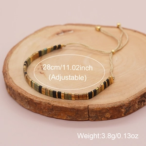 Adjustable Tila bead bracelet with woven cord in black, gold and green ethnic style