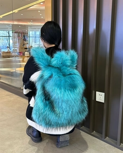 Rucksack aus türkisfarbenem Kunstfell im Lifestyle-Stil an einem Model gezeigt