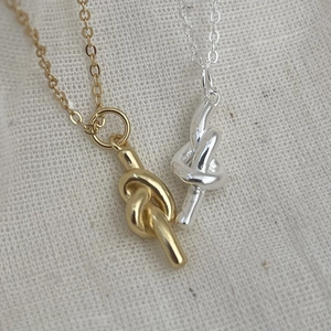 Minimalist 925 sterling silver knot necklaces in gold and silver finish on fabric