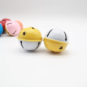 Close-up of 4cm bicolor metal bells with star cutouts and smooth painted finish