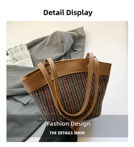 Close-up of retro plaid tweed bucket bag with brown leather handles and metal hardware