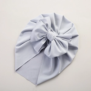 Close-up of light blue baby turban hat with a big bow and waffle texture fabric