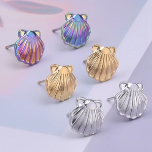 Detailed view of three shell-shaped 304 stainless steel earrings in gold, silver, and iridescent