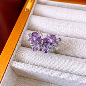 Detail view of a purple butterfly zircon ring with silver setting in a jewelry box