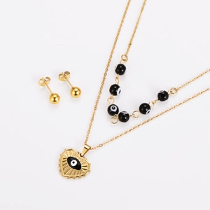 Detailed view of gold evil eye heart pendant necklace with matching stud earrings