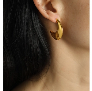 Polished gold crescent moon titanium steel earrings shown on model for size and style