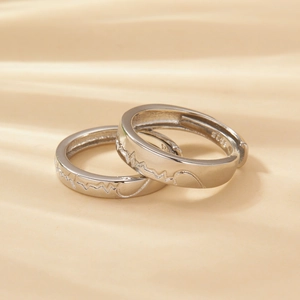 Macro shot of silver S925 sterling silver couple rings with wavy mountain line engraving