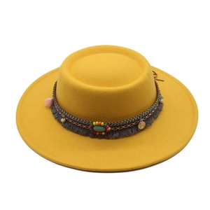Detail of yellow flat-top wide brim hat with bohemian beaded band and coin pendant