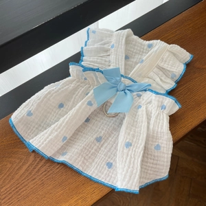 Detailed view of white cotton pet dress with blue heart print and satin bow decoration