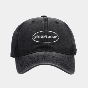 Close-up of black washed denim baseball cap with white Moor'moor embroidery and texture
