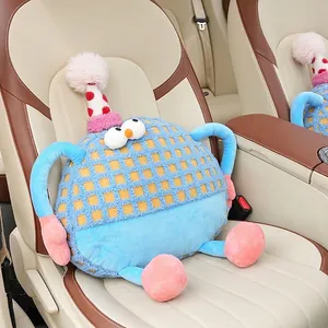 Blue checkered monster car headrest pillow with a party hat on a leather seat