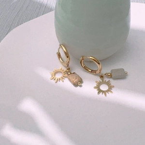 Golden sun earrings with rectangular picture stone pendants on a minimalist stand