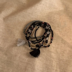 Detailed view of bohemian multilayer beaded bracelets with elegant cotton tassels and charms