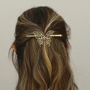 Elegant gold metal butterfly hair pin accessory shown on model's hair with hollow design