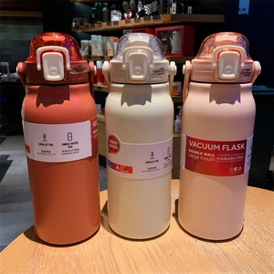 Close-up of 304 stainless steel vacuum flasks in orange, beige, and pink colors