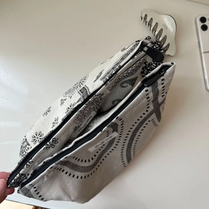 Detail of vintage cotton linen makeup bag featuring paisley print and double zippers