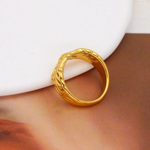 Macro view of a gold-toned French design ring with a unique textured metal surface