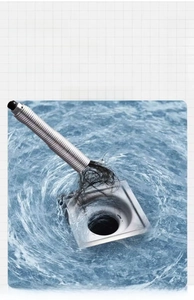 Close-up of flexible drain clog remover tool grabbing hair from a metal floor drain