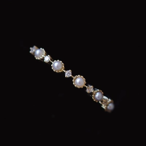 Lace-edged gold ring featuring alternating pearls and diamonds for an elegant vintage look