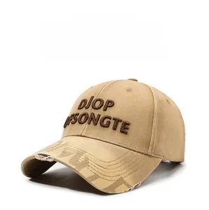 Close-up of khaki baseball cap featuring brown embroidered letters and distressed brim details