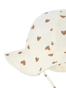 Detail of baby cotton sun hat with brown heart patterns and soft crinkle gauze texture