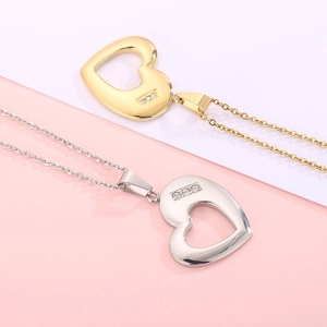 Elegant gold and silver stainless steel heart necklaces with diamonds on pink background