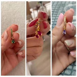 Detailed shot of pear-cut emerald and ruby zircon drop earrings with gold hoop accent