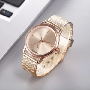 Modern rose gold minimalist women's quartz watch with Milanese mesh strap on grey surface