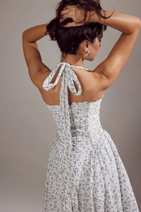 Detail of floral halter neck dress featuring backless tie design and hidden zipper closure