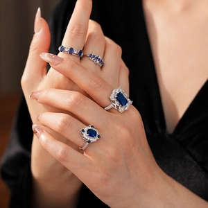 Détail de bagues en zircon bleu étincelant avec dentelle argentée portées au doigt