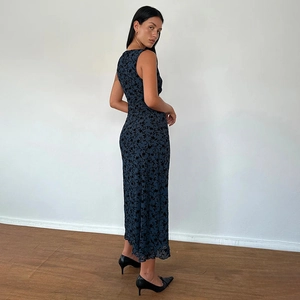 Détail d'une robe longue sans manches bleu marine à fleurs avec coupe cintrée et col en V
